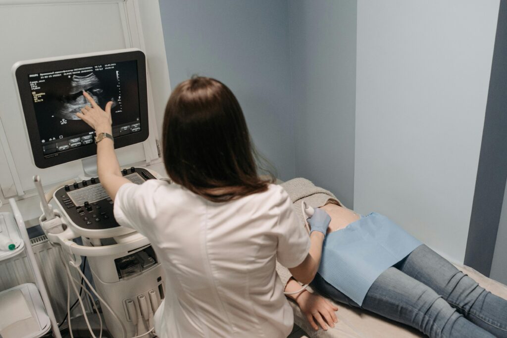 Woman having an ultrasound on pregnant tummy