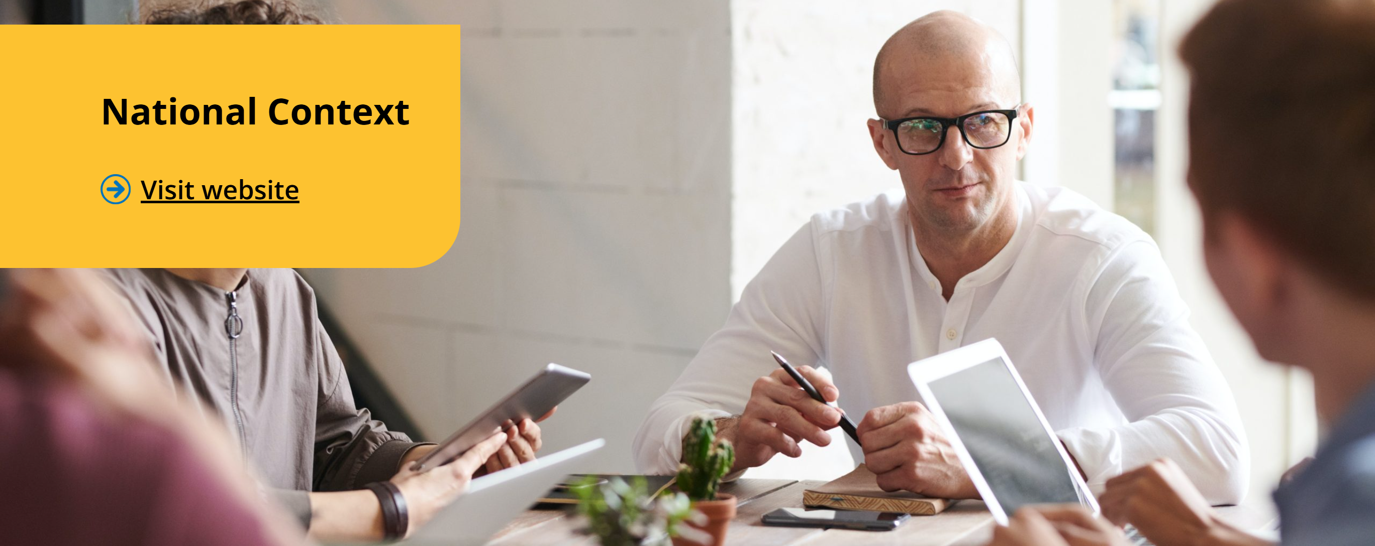 Professional Man sat at a table with other people. Text reads National context, visit website.