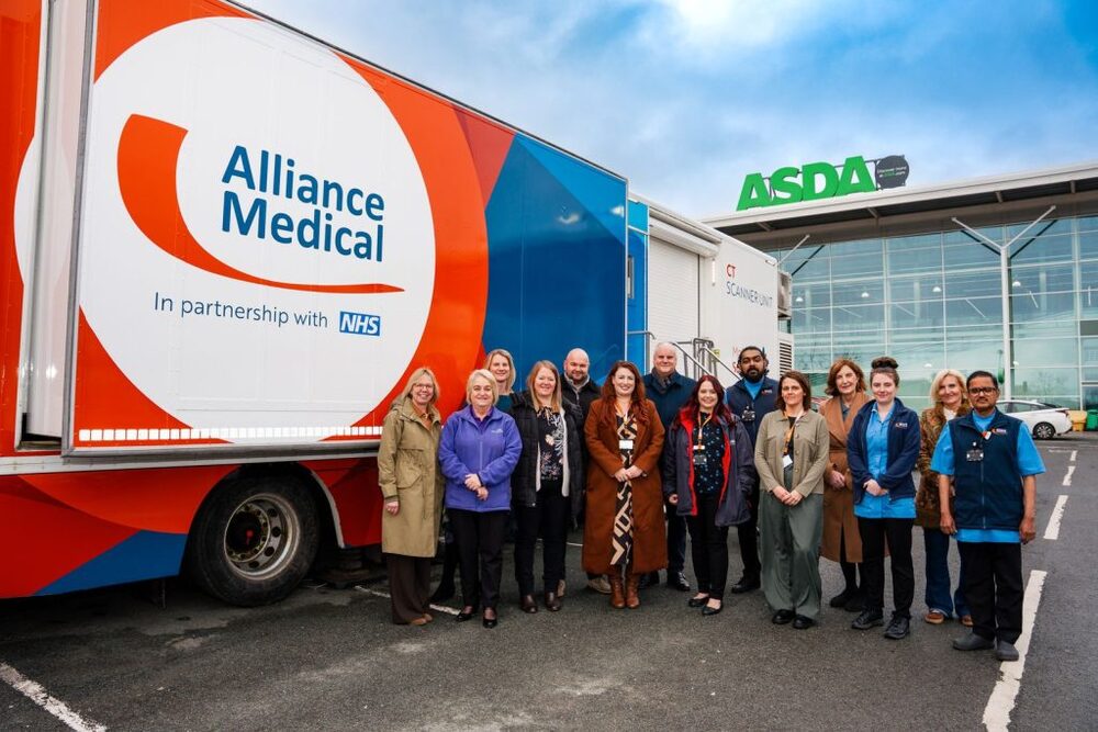 Group of people stood outside a lung cancer screening bus with Asda in the background.