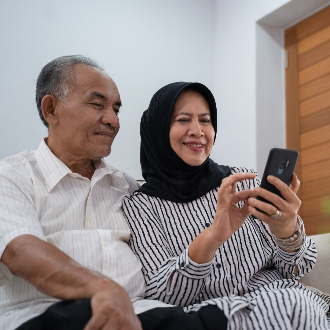 Get Online Week A couple sat looking at a phone screen.