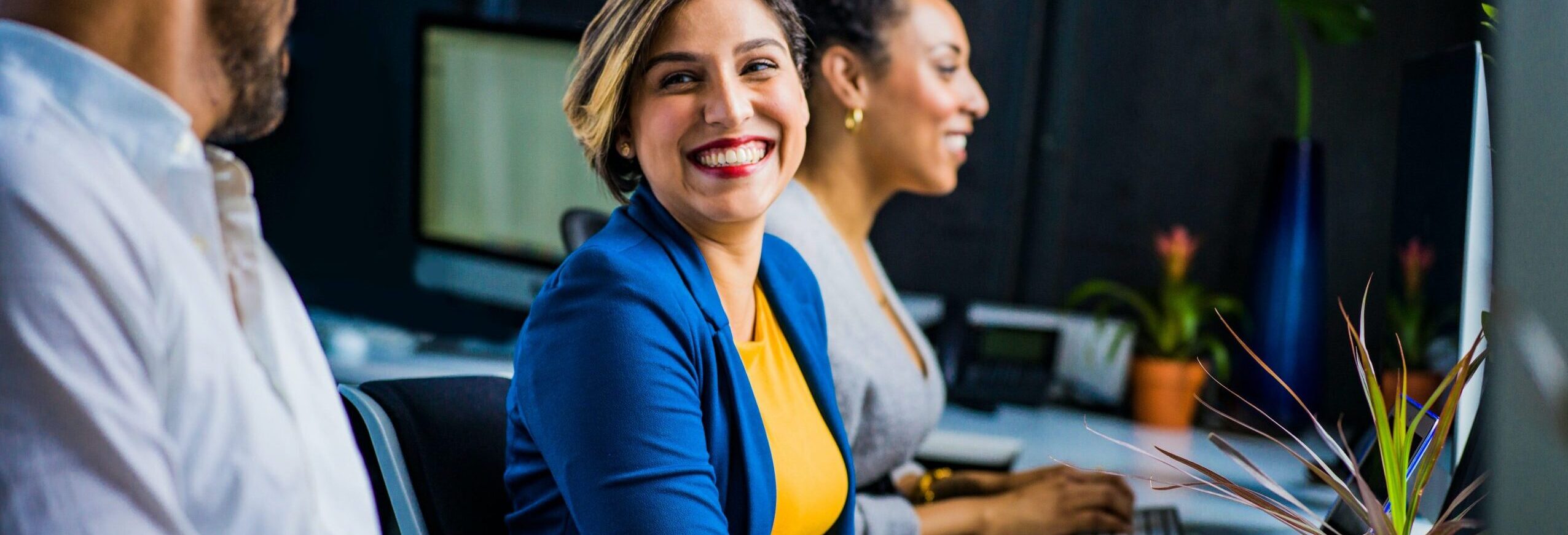 Group of people in a corporate environment working on laptops.